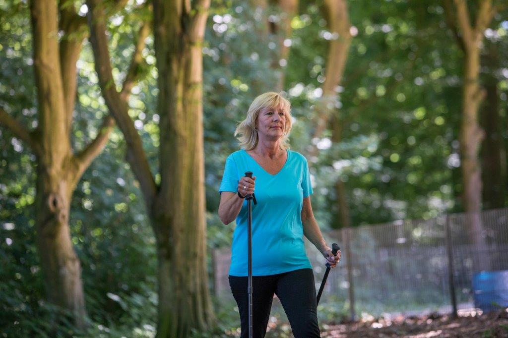 Frau beim Nordic Walking im Wald